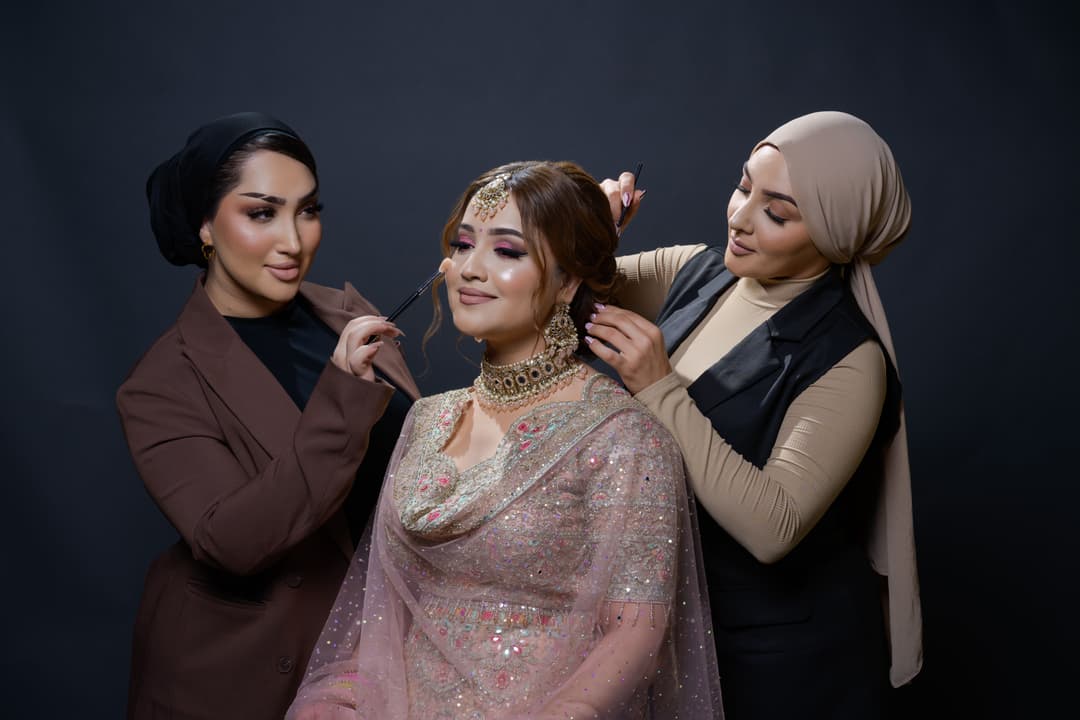 Glam sisters working on client, makeup and hair